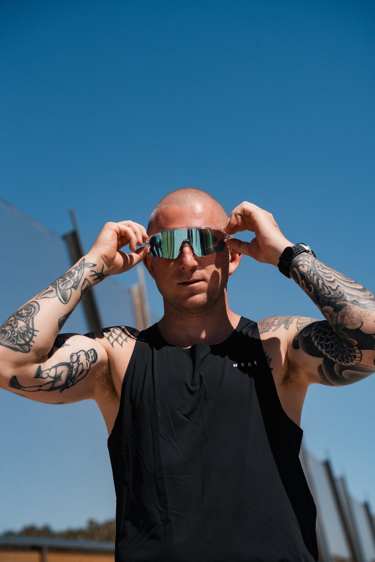 Runner putting on Altra Glacier sunglasses